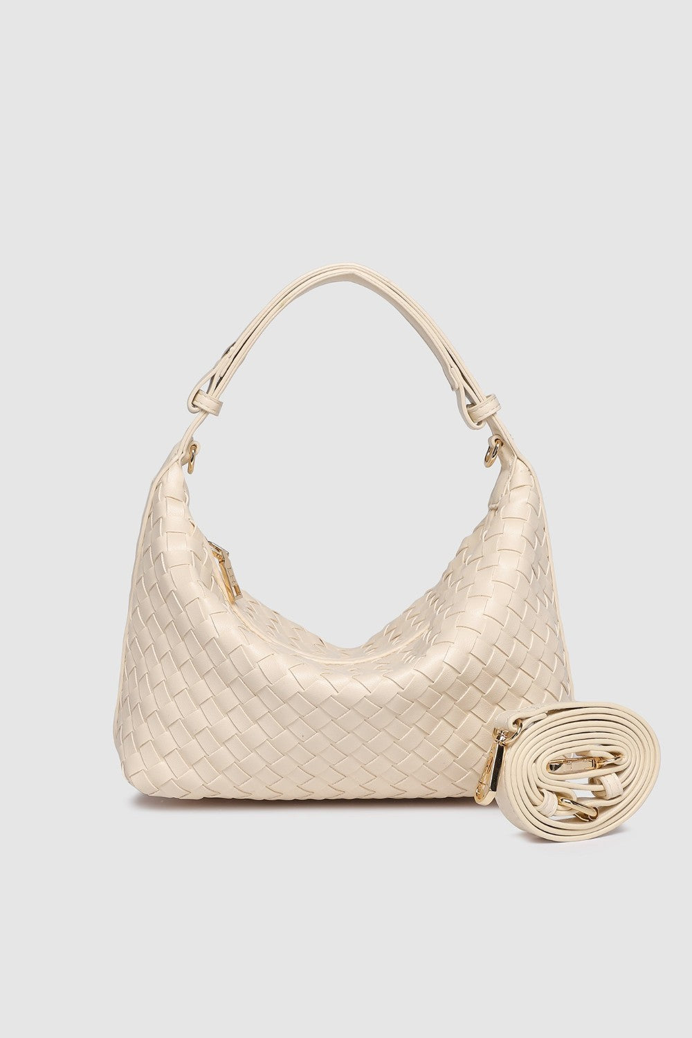 Beige woven handbag with extra strap on a light gray background