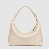 Beige woven handbag on a light gray background