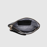 View looking down into a zippered clutch showing a black and white striped lining on a light background.