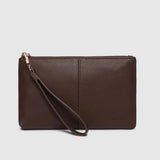 A dark brown pebbled leather clutch wallet with a wristlet strap and gold-tone zipper pull, shown against a light gray background.