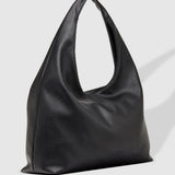 A black slouchy leather shoulder bag with a single integrated strap, photographed on a light gray background with a soft shadow.