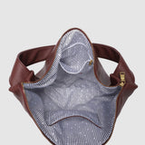 Burgundy pleather bag with striped interior on a light gray background