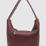 Burgundy pleather handbag with a gold zipper on a light gray background