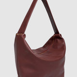 Burgundy pleather handbag on a light gray background
