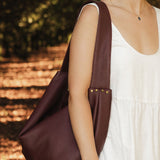 Woman carrying a burgundy pleather bag outdoors