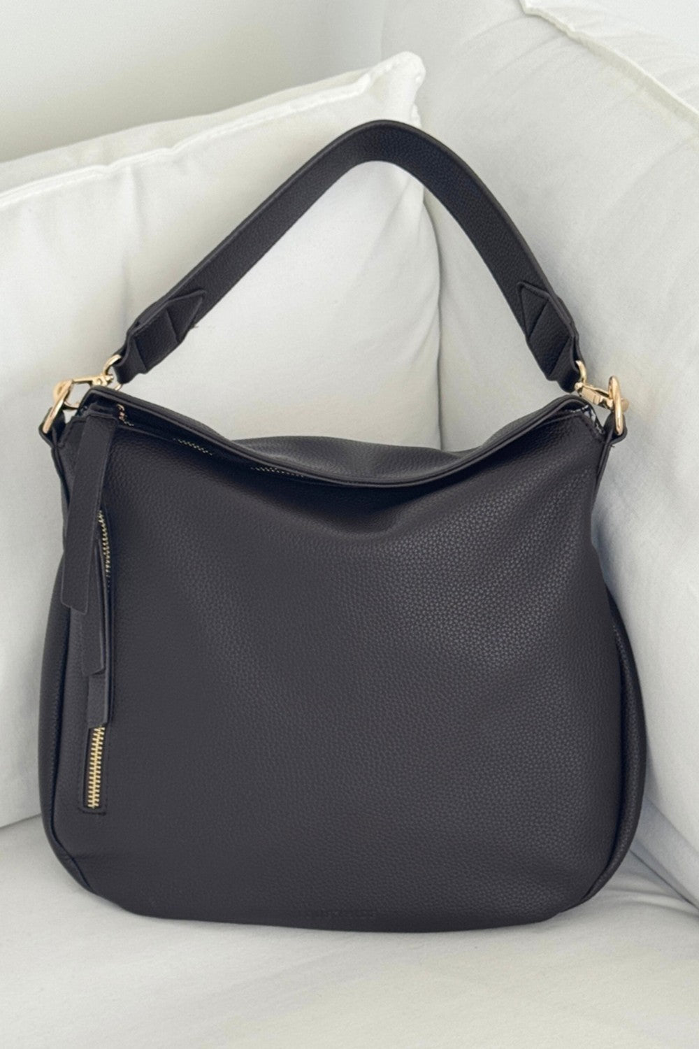 Brown handbag with gold accents on a white surface