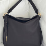 Brown handbag with gold accents on a white surface