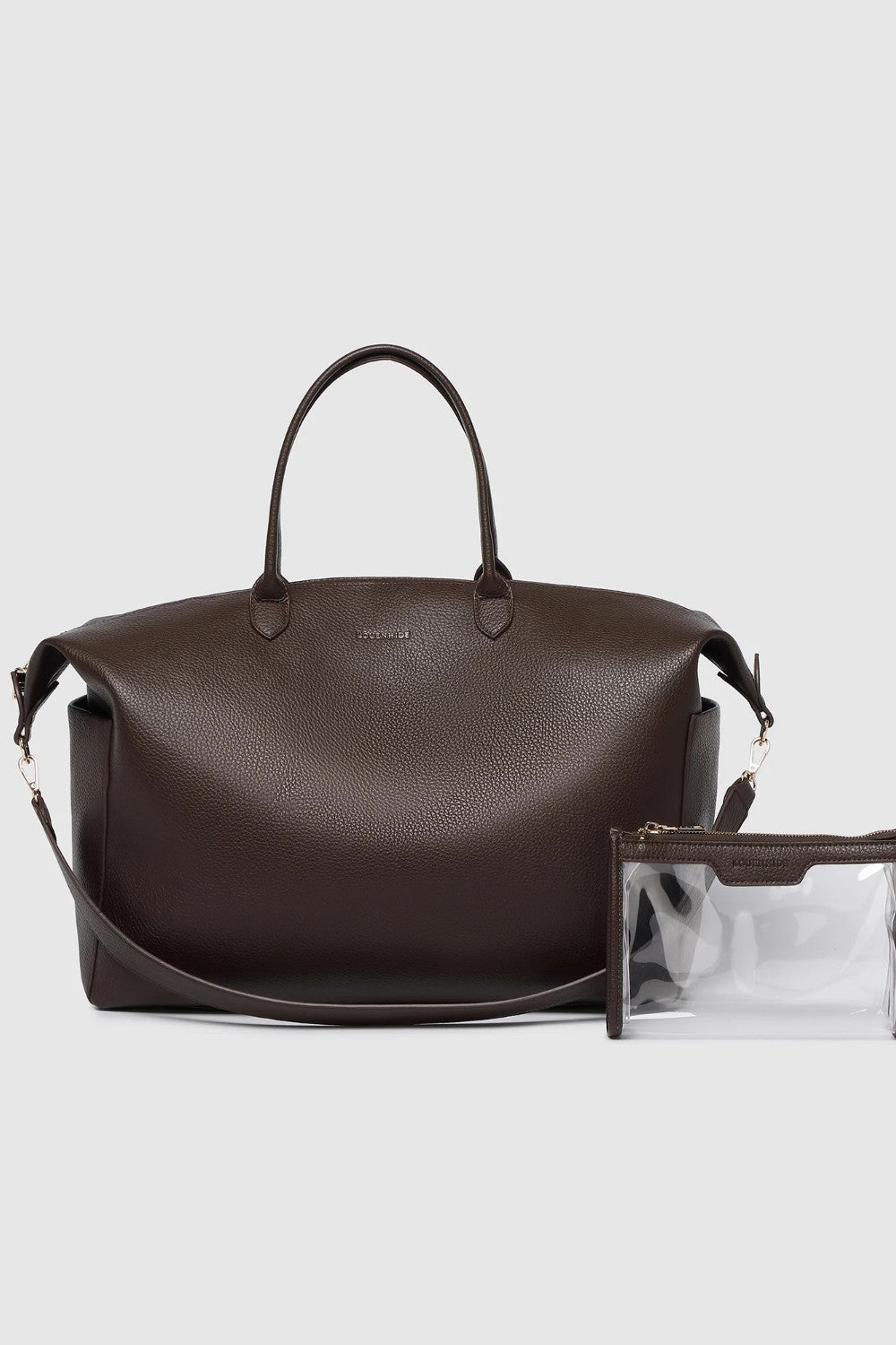A large brown pebbled leather duffel bag with handles and a detachable strap with a clear pouch on a light background.