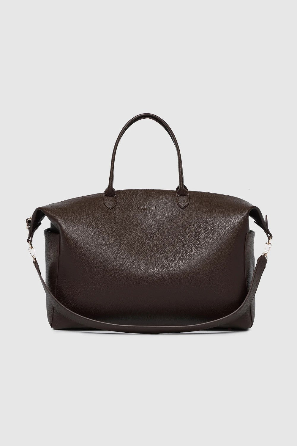 A large brown pebbled leather duffel bag with handles and a detachable strap on a light background.