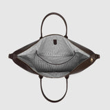 Looking down into a large brown bag with a zipper closure, interior pocket, and black and white striped lining.