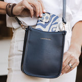 Person holding a navy blue handbag with 'Louenhide' branding.