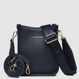 Navy handbag with gold accents on a light gray background