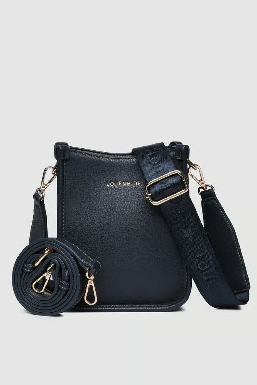 A navy pebbled leather crossbody bag with a matching rolled-up strap, gold-tone hardware, and a wide adjustable shoulder strap printed with 'LOUENHIDE' and a star. The brand name 'LOUENHIDE' is embossed on the front.