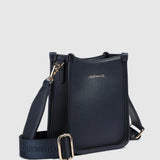 A navy pebbled leather crossbody bag with gold-tone hardware, and a wide adjustable shoulder strap printed with 'LOUENHIDE' and a star. The brand name 'LOUENHIDE' is embossed on the front.