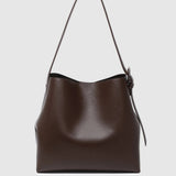 A dark brown leather shoulder bag with a single strap shown against a light gray background.