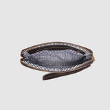 Zipped pouch with striped interior on a light gray background