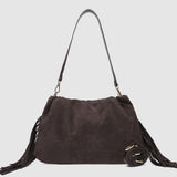 Brown suede handbag with fringes on a light gray background