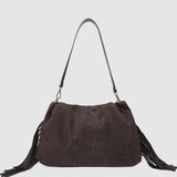 Brown suede handbag with fringe details on a light gray background
