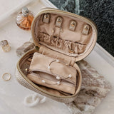 Open champagne coloured jewellery case on vanity setting background