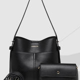 Black handbag set with matching pouch on a light gray background