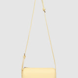 Yellow handbag with a strap on a light gray background