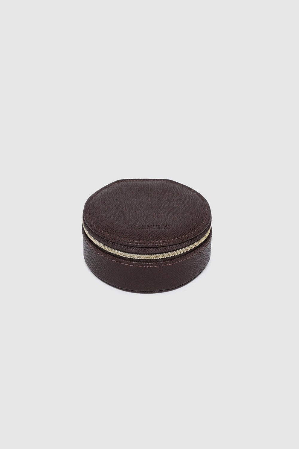 A small round dark brown leather jewelry box with a gold zipper, on a white background.