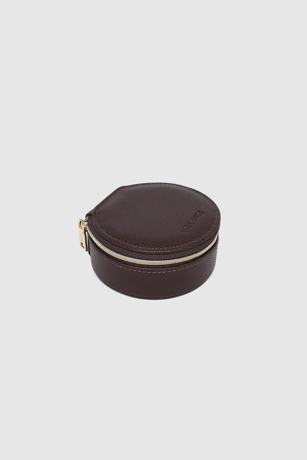 A small round dark brown leather jewelry box with a gold zipper, on a white background.