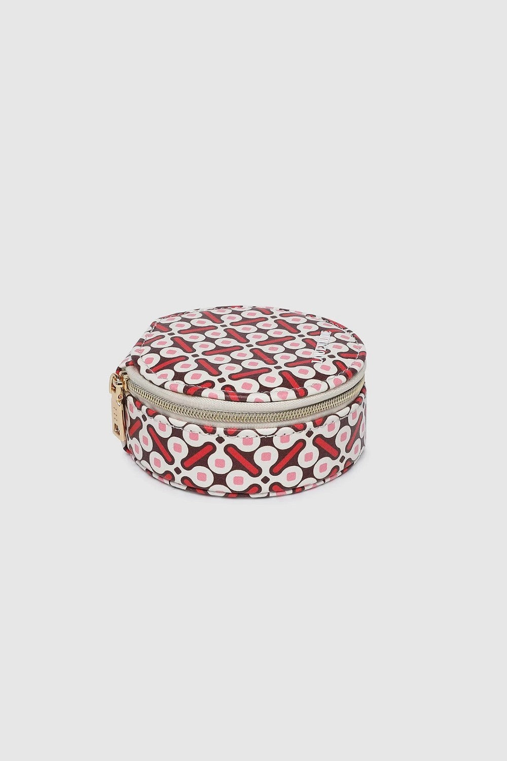 A small round zippered case with a red, white, and black geometric pattern, featuring a gold-tone zipper pull, shown on a light gray background.