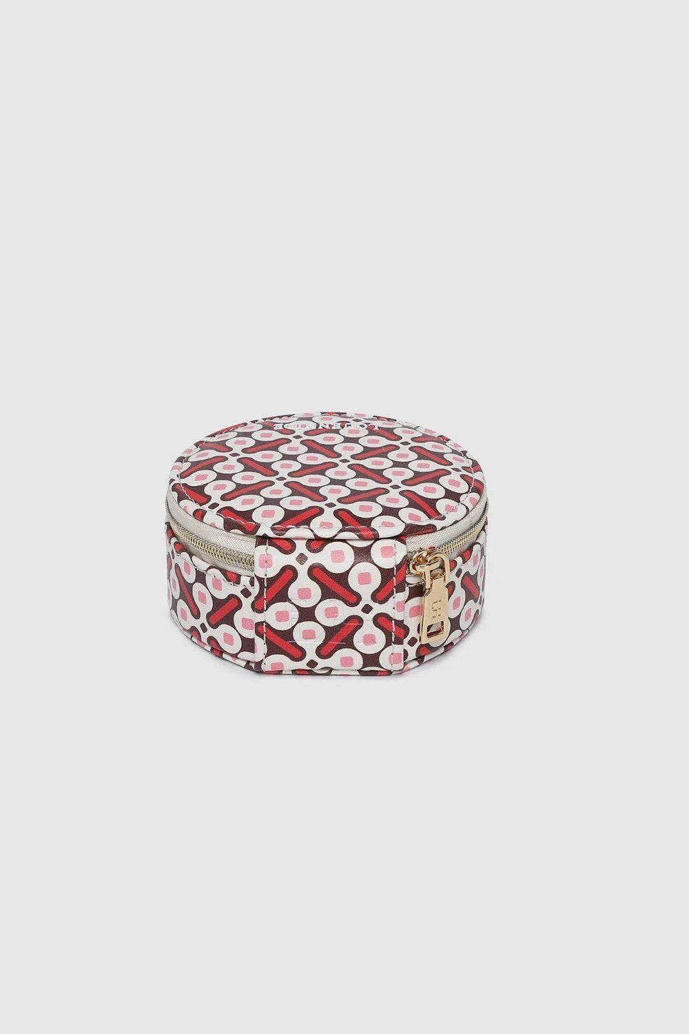 A round zippered jewellery case with a red, black, and white geometric pattern, shown against a solid light gray background.