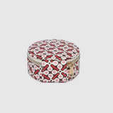 A round zippered jewellery case with a red, black, and white geometric pattern, shown against a solid light gray background.