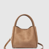 A tan leather handbag with a top handle and a detachable shoulder strap, displayed against a light gray background.
