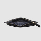 Black pleather bag with gold zipper on a light gray background