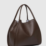 A dark brown leather slouchy handbag with double shoulder straps, shown from a three-quarter angle against a light gray background.