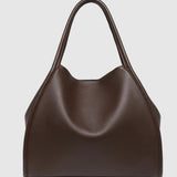 A dark brown leather slouchy handbag with double top handles, photographed against a neutral light gray background.