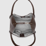 A brown leather shoulder bag shown from a top-down view, featuring a striped patterned lining visible inside.