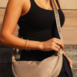 Person holding a beige shoulder bag with 'LOUENHIDE' branding.