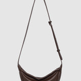 Brown shoulder bag with a strap on a light gray background
