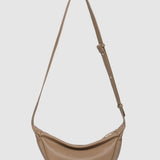 Beige shoulder bag with a strap on a light gray background