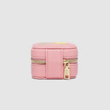 Pink jewelry box with gold zipper on a light gray background