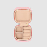 Pink jewelry case with open lid on a light gray background