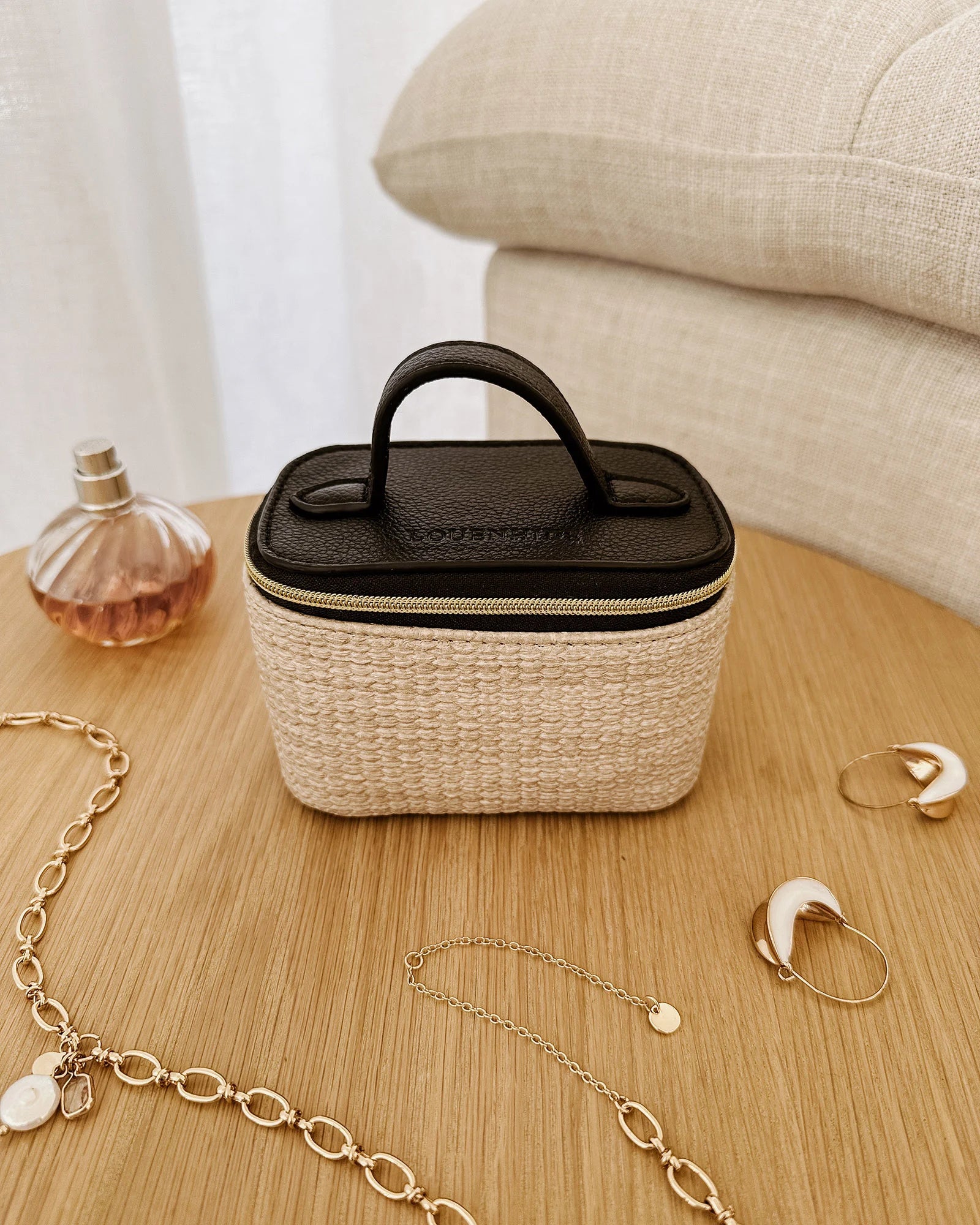 The Louenhide Trudy Jewelry Box is the perfect solution to keeping your valuables safely organized on the go. This compact travel jewelry case fits seamlessly into your luggage without taking up space. The secure zip closure ensures your jewelry stays protected, while the textured raffia and contrasting faux leather exterior add a touch of understated luxury to your travel style. 