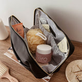 Open makeup bag with skincare products on a wooden surface