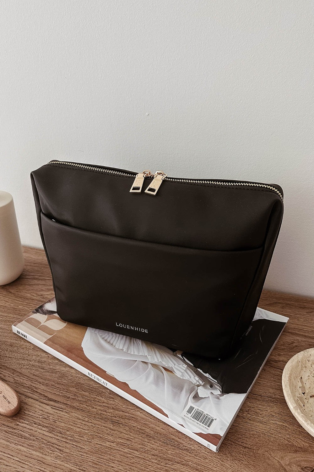 Black pleather bag on a magazine with a minimal background