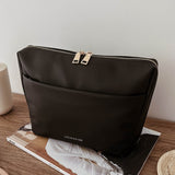 Black pleather bag on a magazine with a minimal background