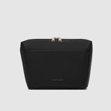 Black cosmetic bag with gold accents on a light gray background
