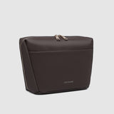 Brown toiletry bag with gold zipper on a light gray background
