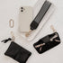 Phone case with strap, keychain, and pouch on a textured white surface