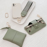 Set of green pleather accessories including a pouch, keychain, and phone case on a white textured background.