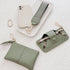 Set of green pleather accessories including a pouch, keychain, and phone case on a white textured background.