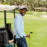 Man on a golf course with a golf cart and club